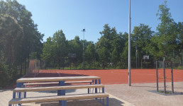 Bänke vor einem roten Sportfeld