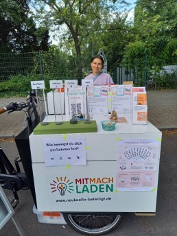 Mitarbeiterin steht hinter Lastenrad- Stand