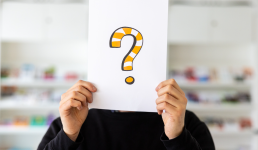 Persön hält ein Blatt mit einem Fragezeichen vors Gesicht 