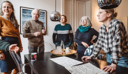 Fünf Menschen stehen um einen Tisch