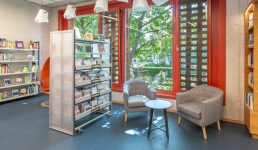 Bücherregale in einer Bibliothek, Sitzecke und bodentiefes Fenster 
