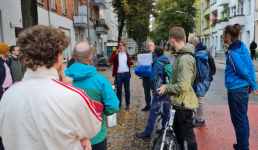 Menschen stehen auf einer Straße und hören einer Person zu