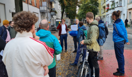 Menschengruppe versammelt sich auf der Straße und hört einer Präsentation zu