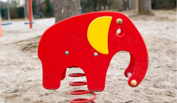 Roter Elefant als Wipptier auf einer Sandfläche