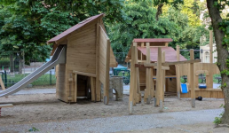 Spielplatz mit Spielgeräten aus Holz und einer Rutsche
