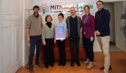Foto mit 6 Personen vor einer roten Couch